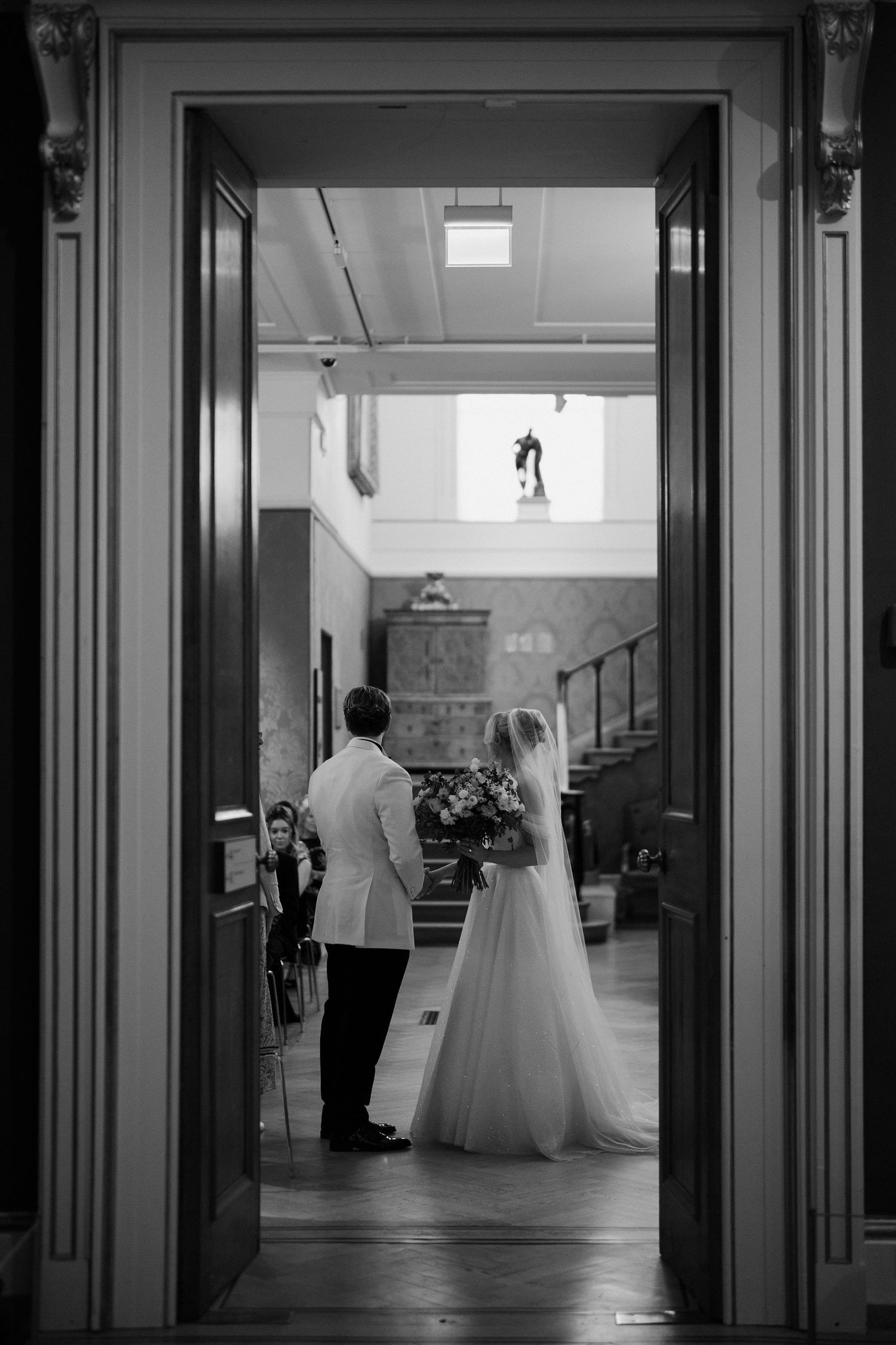 bride and groom framed in doorway during the ceremony in the European art gallery at the ashmolean museum