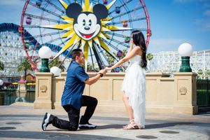 Proposal moment at Disney California Adventure with Mickey's Fun Wheel in background.