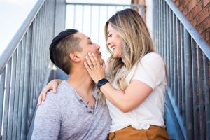 Joyful couple sharing intimate moment on urban staircase.