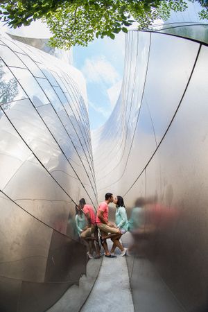 Artistic reflective photo through metallic sculpture with trees overhead.