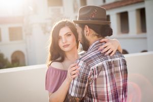 A tender moment between a couple during golden hour against white architecture.