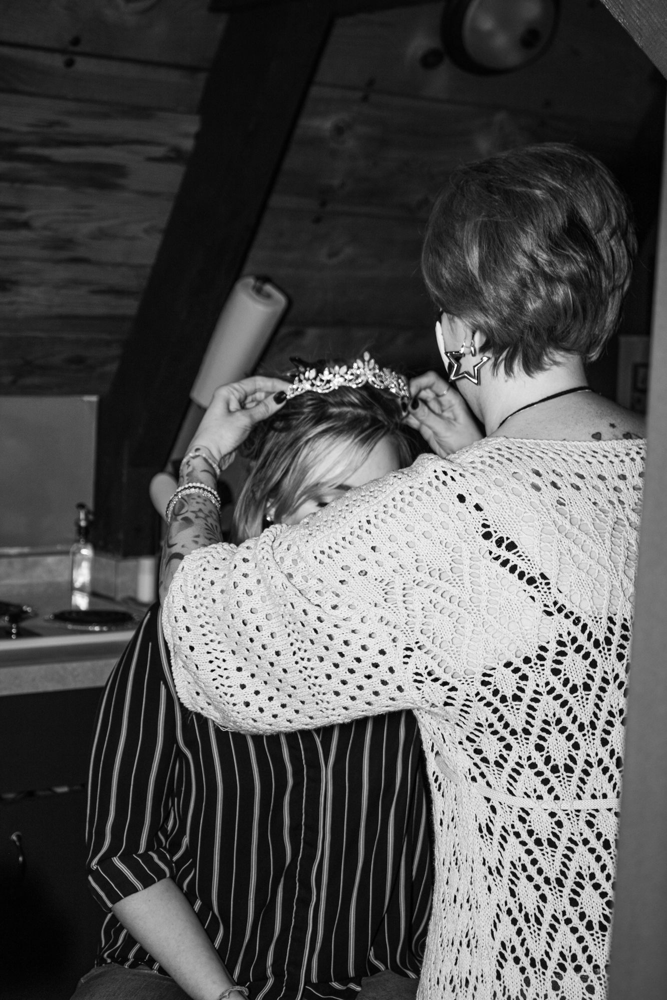 Black and white photo series showing an embrace between two people, with one wearing a white lace top and the other in stripes.
