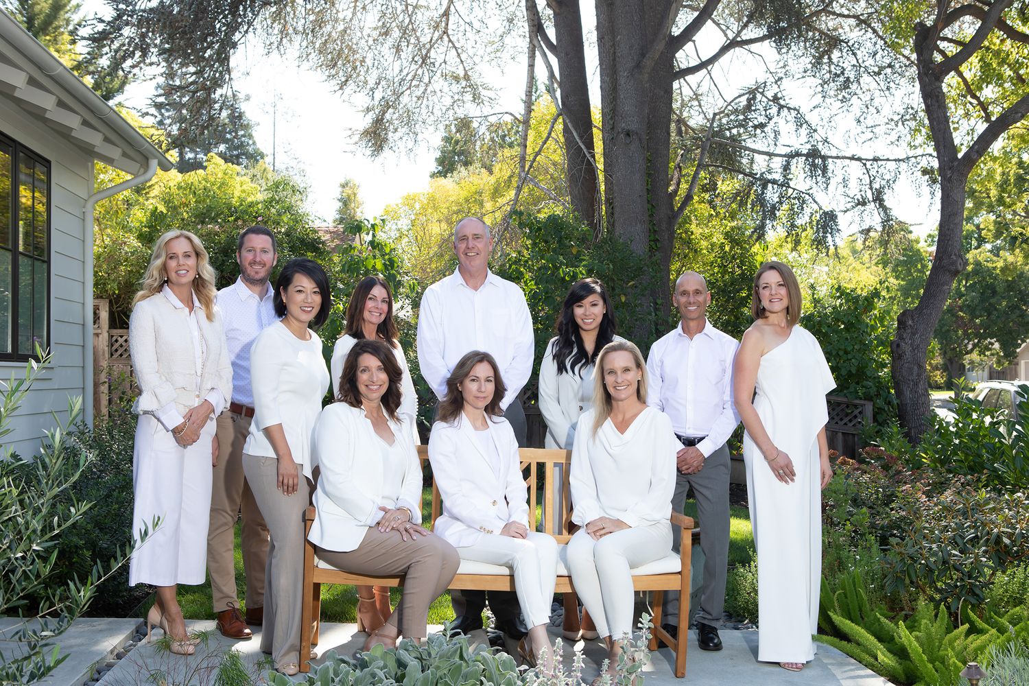 Caroline Huo and her real estate team's outdoor branding group photo everyone is wearing  white outfits