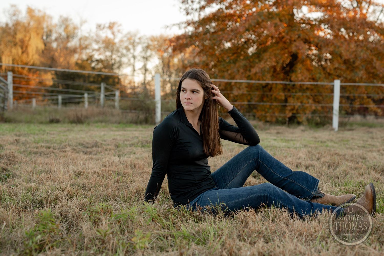 Relaxed lifestyle portrait against fall colors and white fencing.