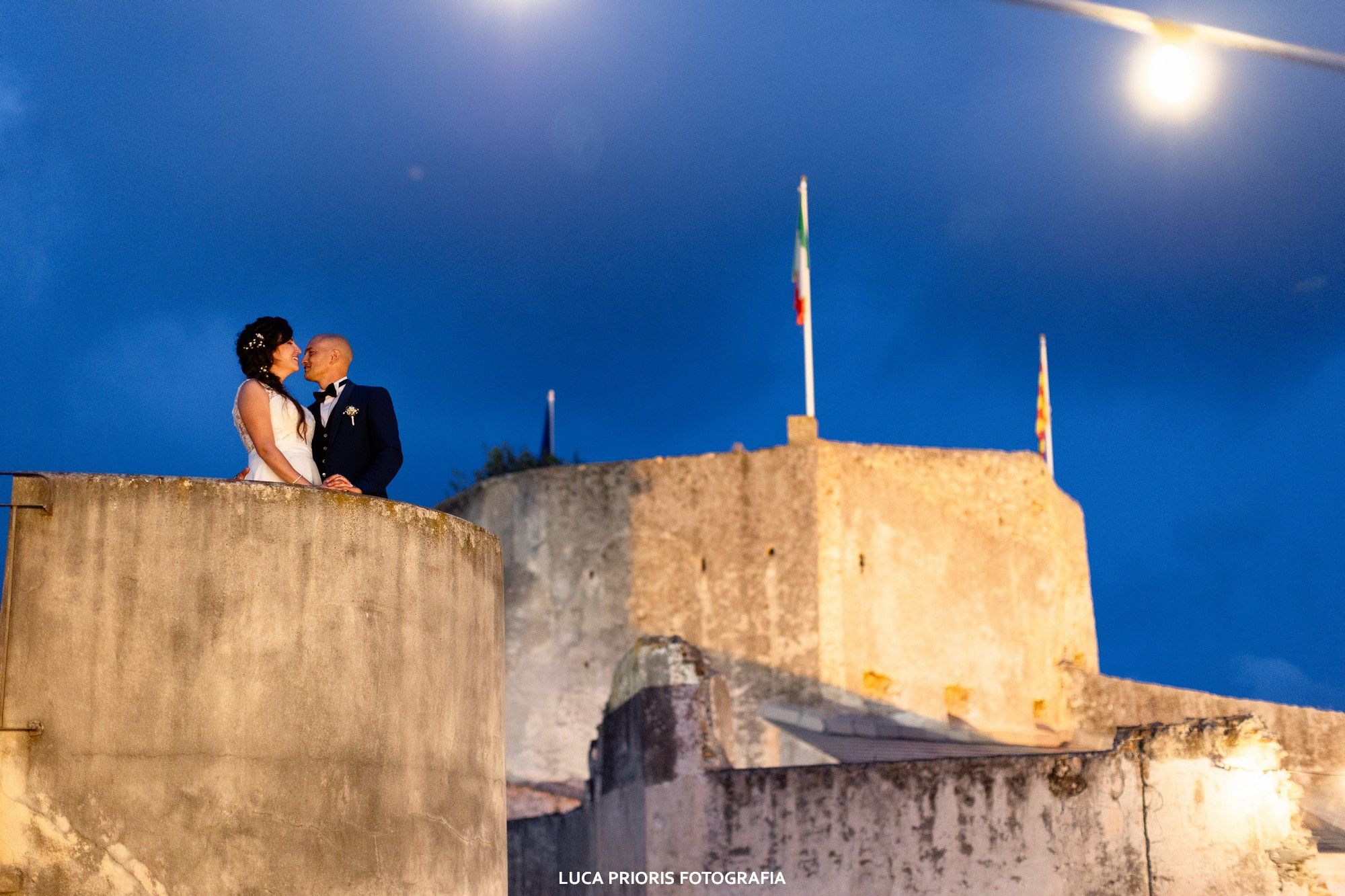 gli sposi si baciano alla fortezza al tramonto