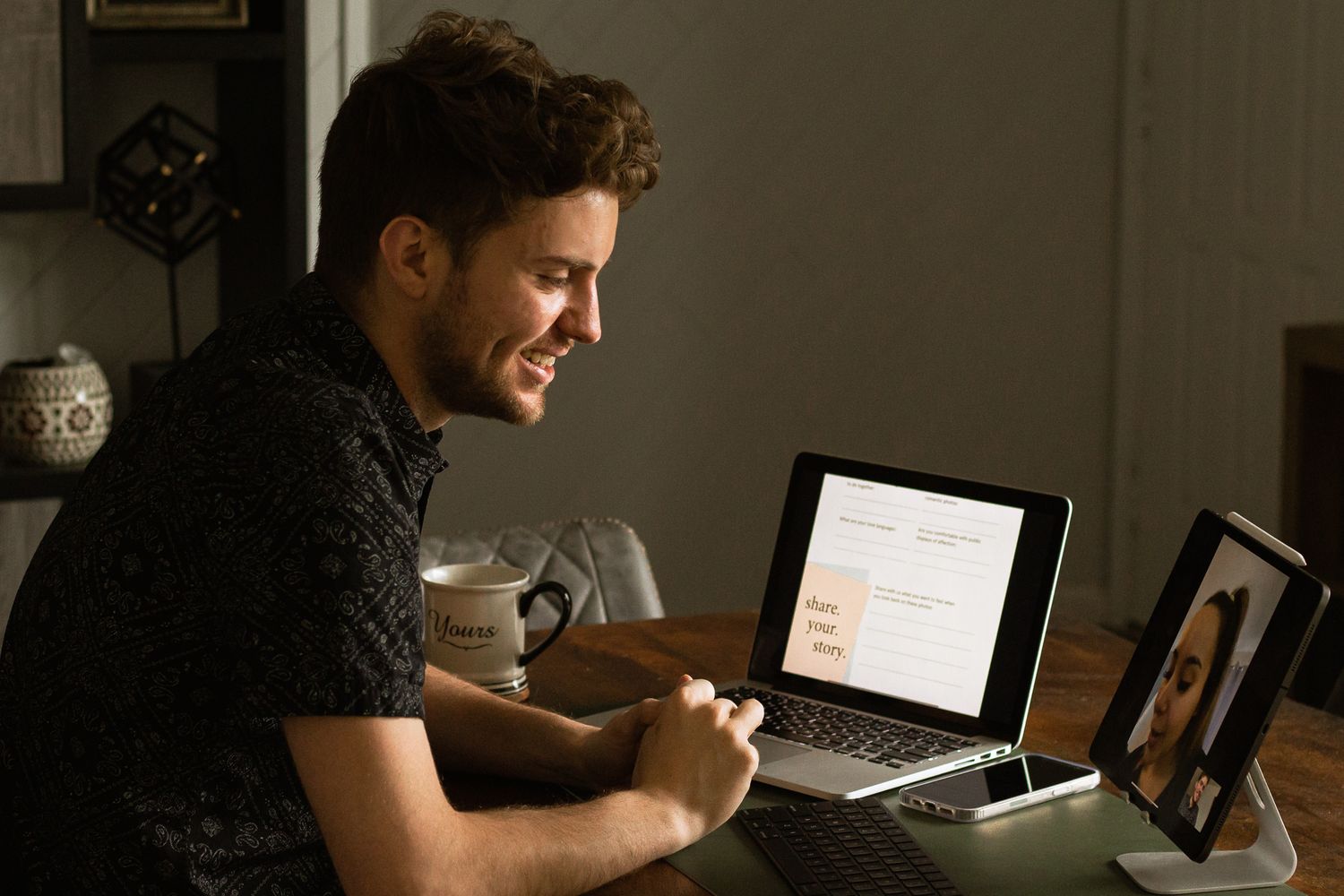 Person studying and working on laptop in dimly lit room.