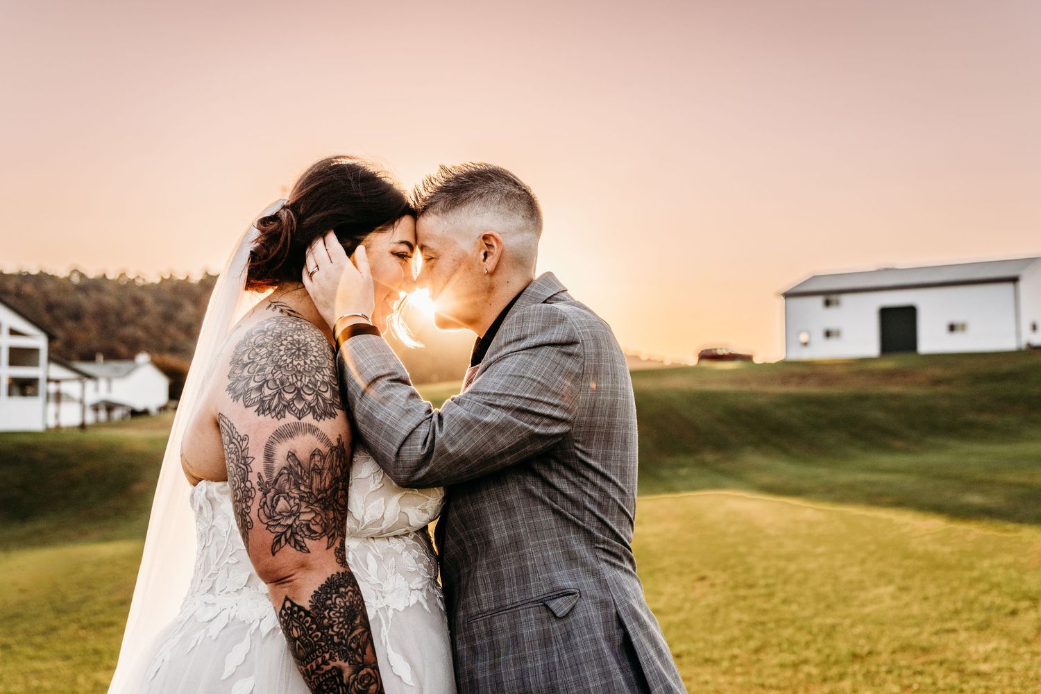 Lesbian couple shares an intimate moment, sunflare, sunset, Bailey Barns Venue in Fairview, WV