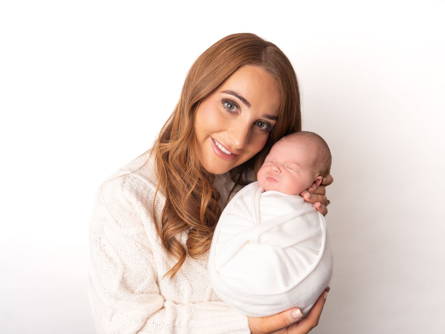 Mum holding wrapped baby in white at newborn session in Doncaster with client of Heather Katie Photography.