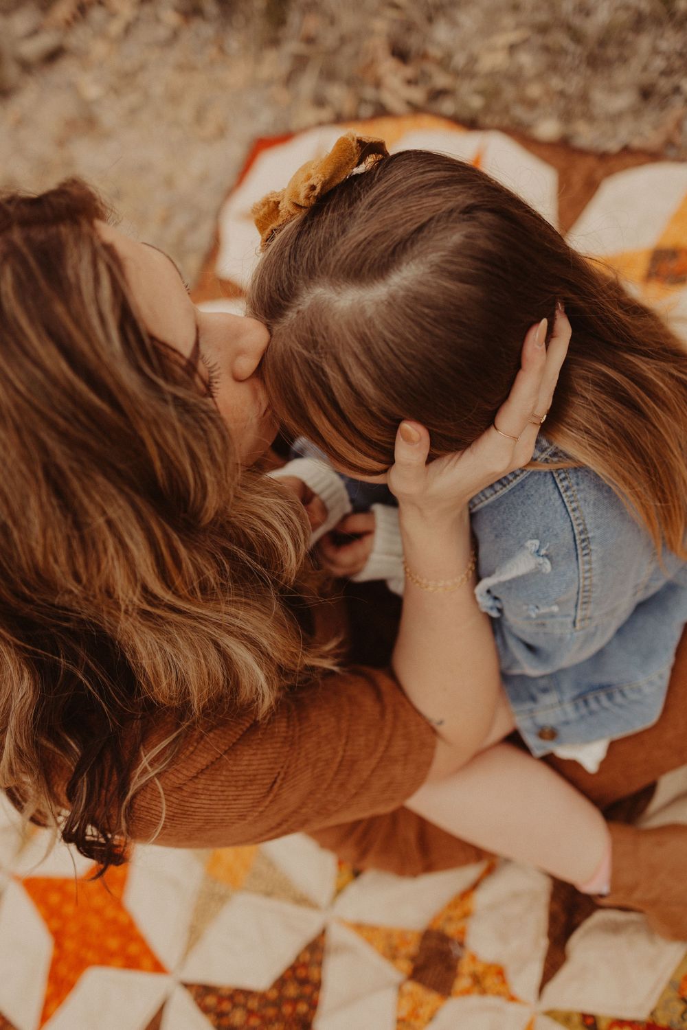 details of mom sitting on blanket with kisses during a family photography session