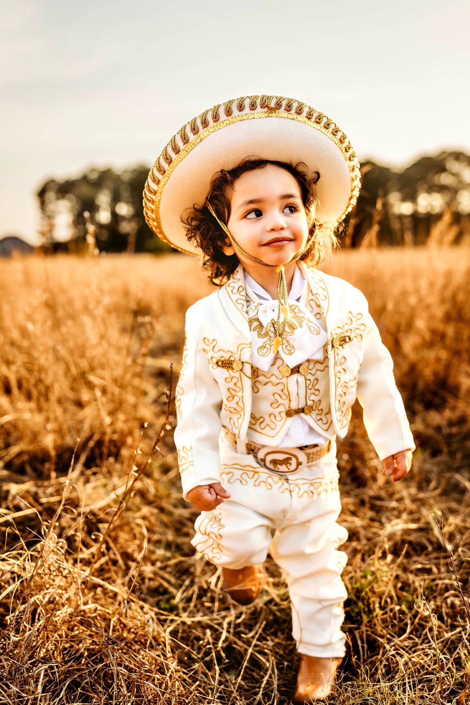Baby boy in a sun drenched field with gorgeous hat in Connecticut