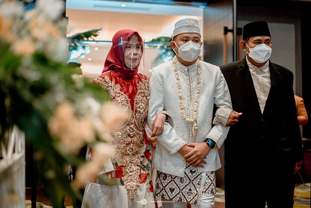 Wedding party members in traditional Indonesian attire walking together.