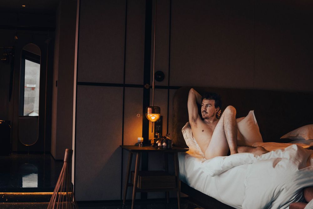 Cozy bedroom scene with soft lighting and white bedding.