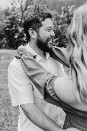 Black and white portrait of couple sharing intimate moment outdoors.