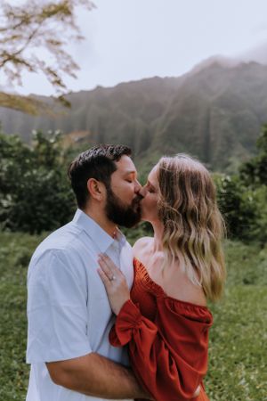 Romantic kiss captured in sequence against misty mountain backdrop.