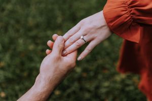 Close-up shots of hands during a romantic proposal moment in nature.