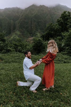 A romantic proposal sequence photographed in a lush mountain setting.