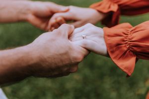 Detail shots of hands reaching toward each other during an emotional proposal sequence.