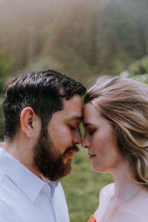Intimate close-up portrait of couple about to kiss in natural outdoor setting.