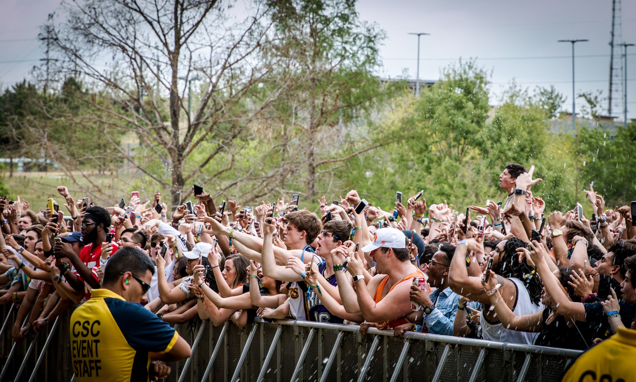 Excited crowd with raised arms at an outdoor concert or festival.