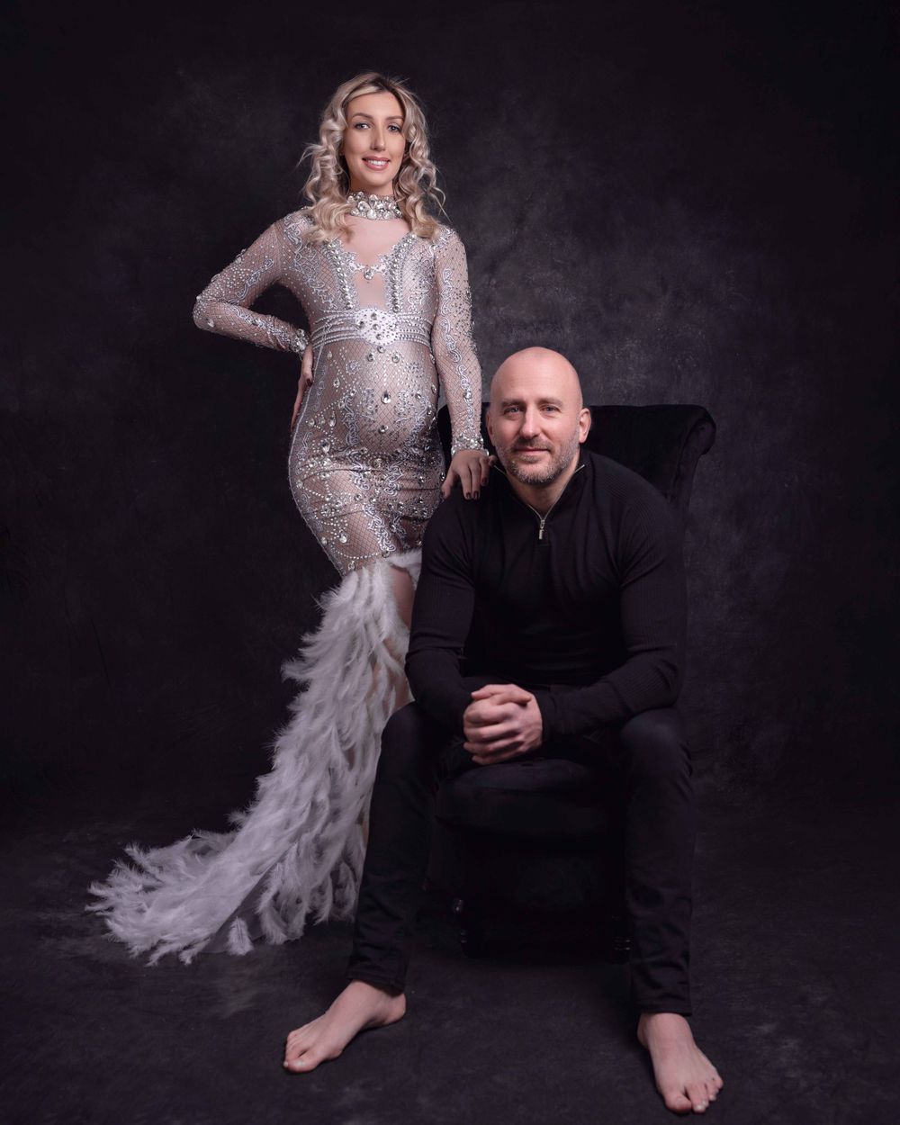Studio portrait with sparkly silver gown and black outfit against dark background.