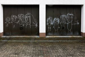 Familienbild von einem Kind mit Kreide auf Garage gemalt