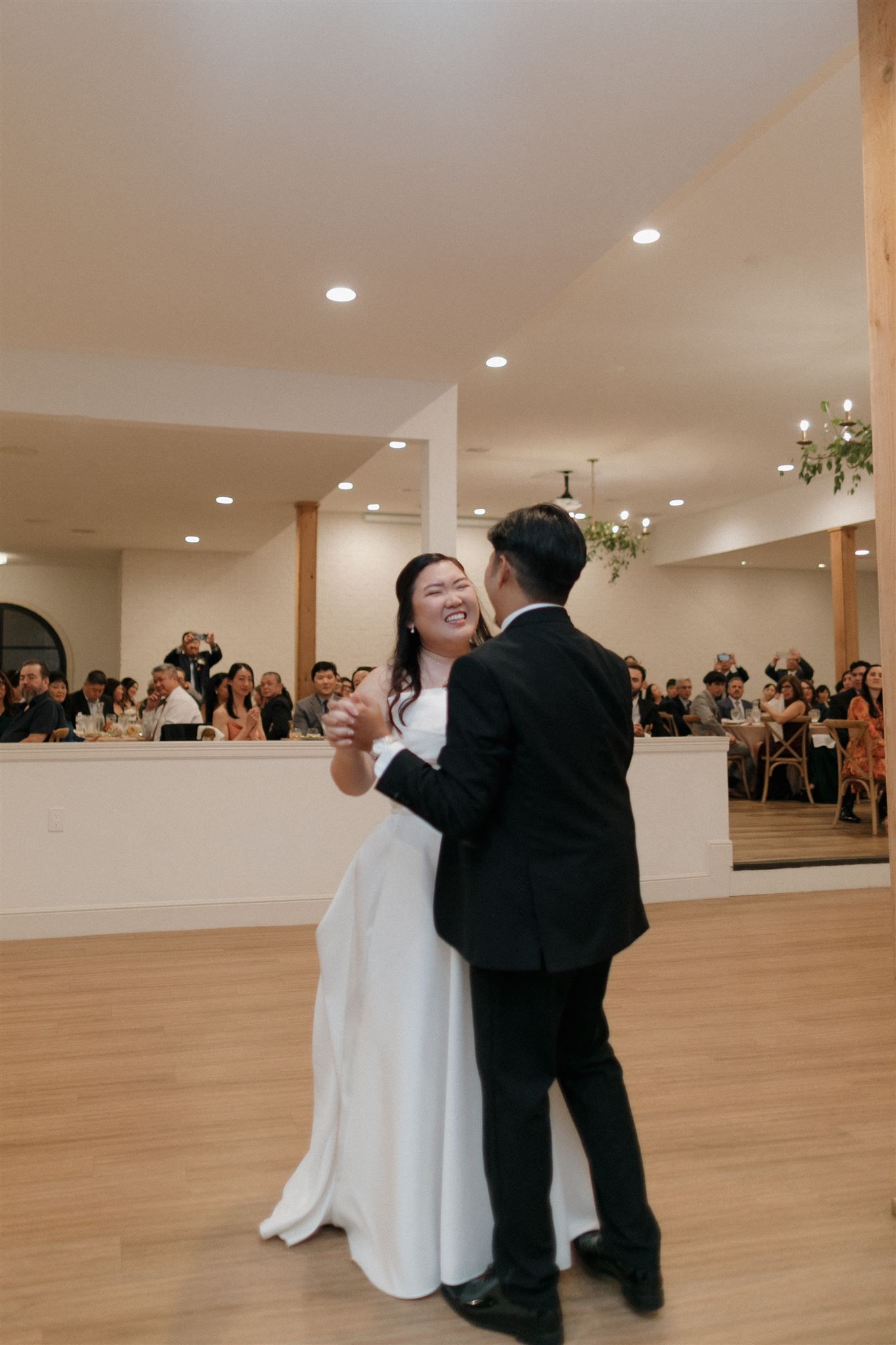 Wedding dance celebration in modern venue with natural lighting.