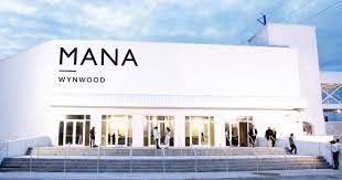 Modern white facade of MANA Wynwood art gallery under blue sky.