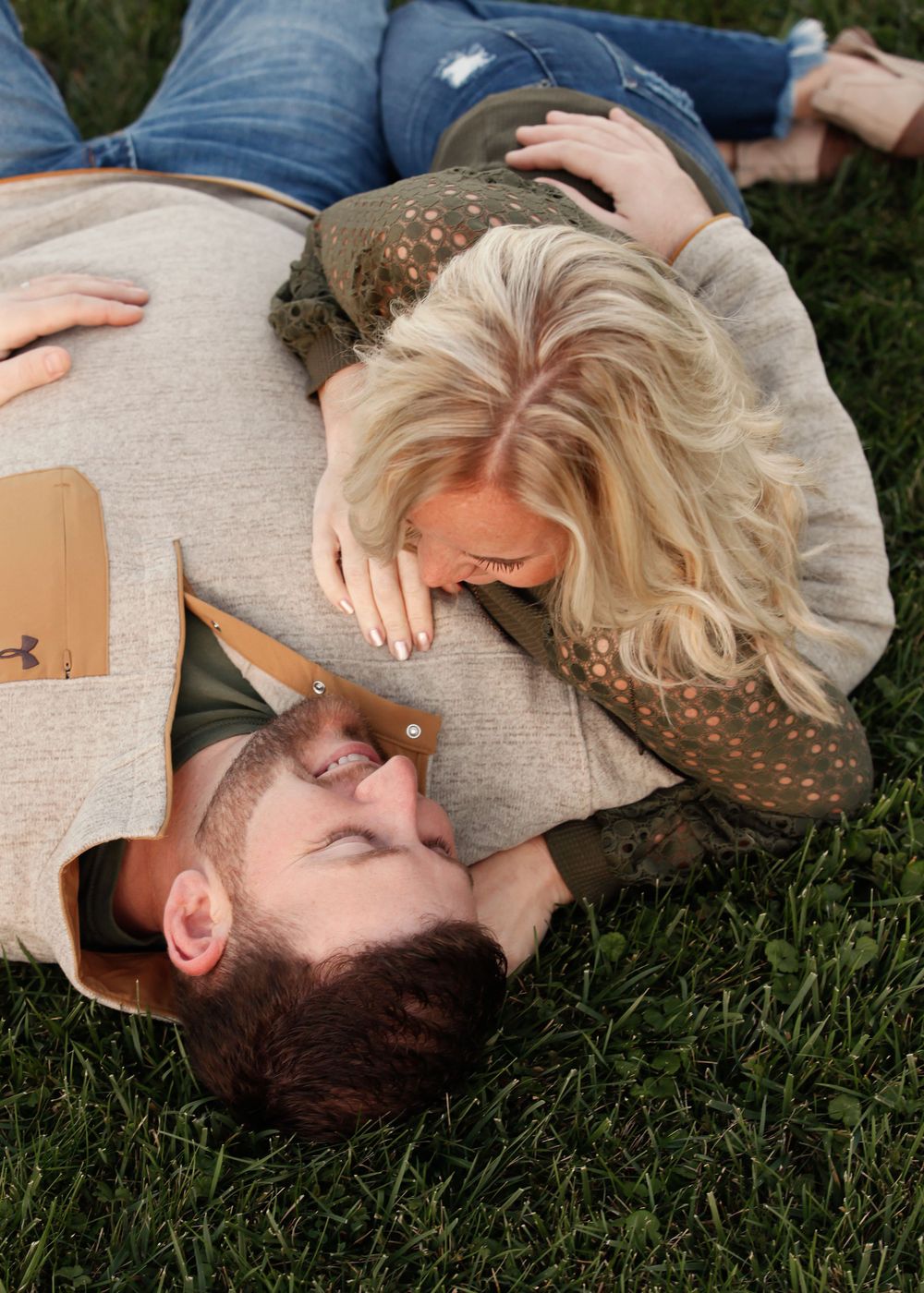 Candid sequence of couple relaxing on grass during casual outdoor photoshoot.