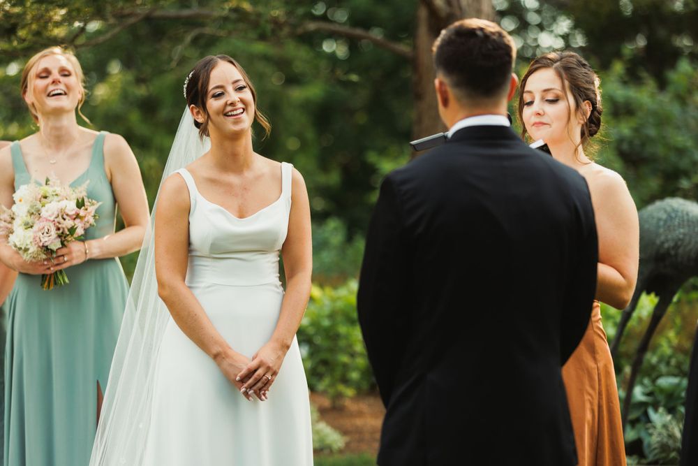 Wedding party lined up outdoors with bridesmaids in mint dresses and groomsmen in black tuxedos.