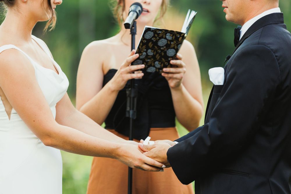 Close-up of wedding ceremony vow exchange in garden setting.