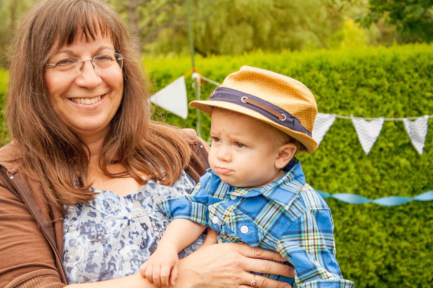 An outdoor family portrait with bunting decorations in a green garden setting.