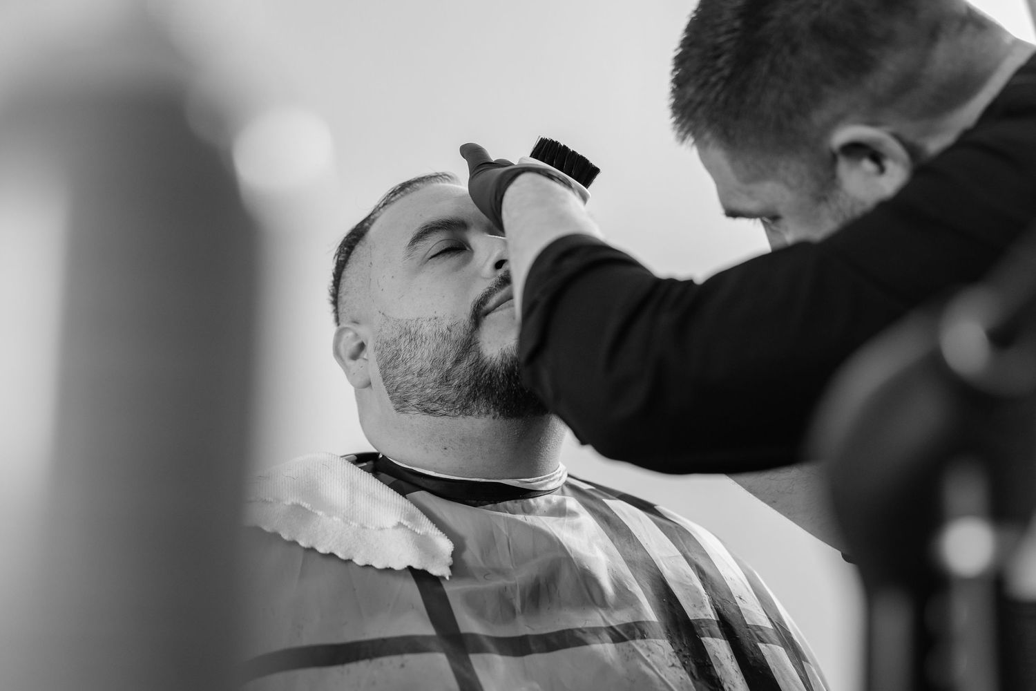 Professional beard trimming service captured in dramatic black and white photography.