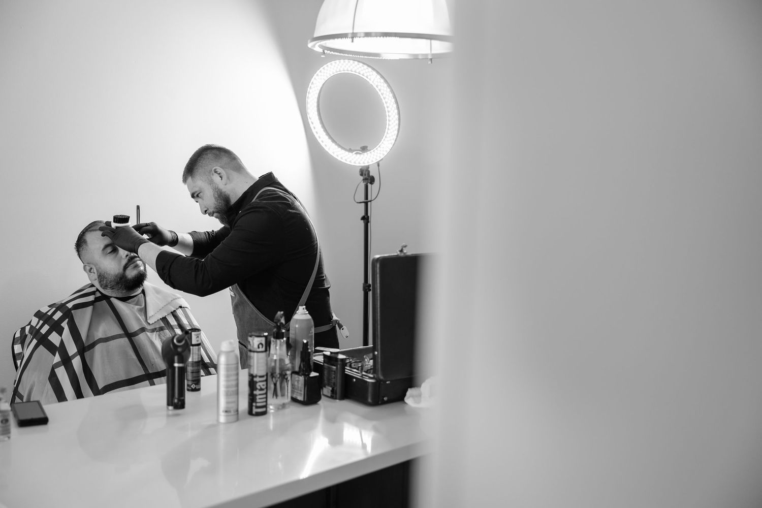 groom getting beard done by barber