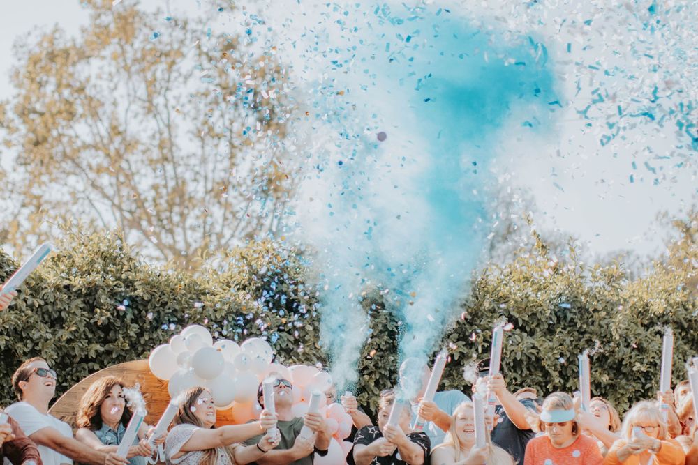 Colorful blue smoke bombs creating a vibrant display during an outdoor celebration.
