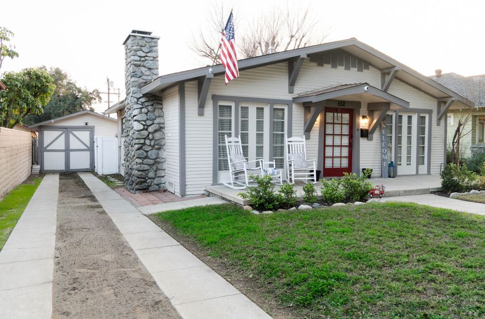 Exterior view of a modern residential home with American flag and landscaped front yard.