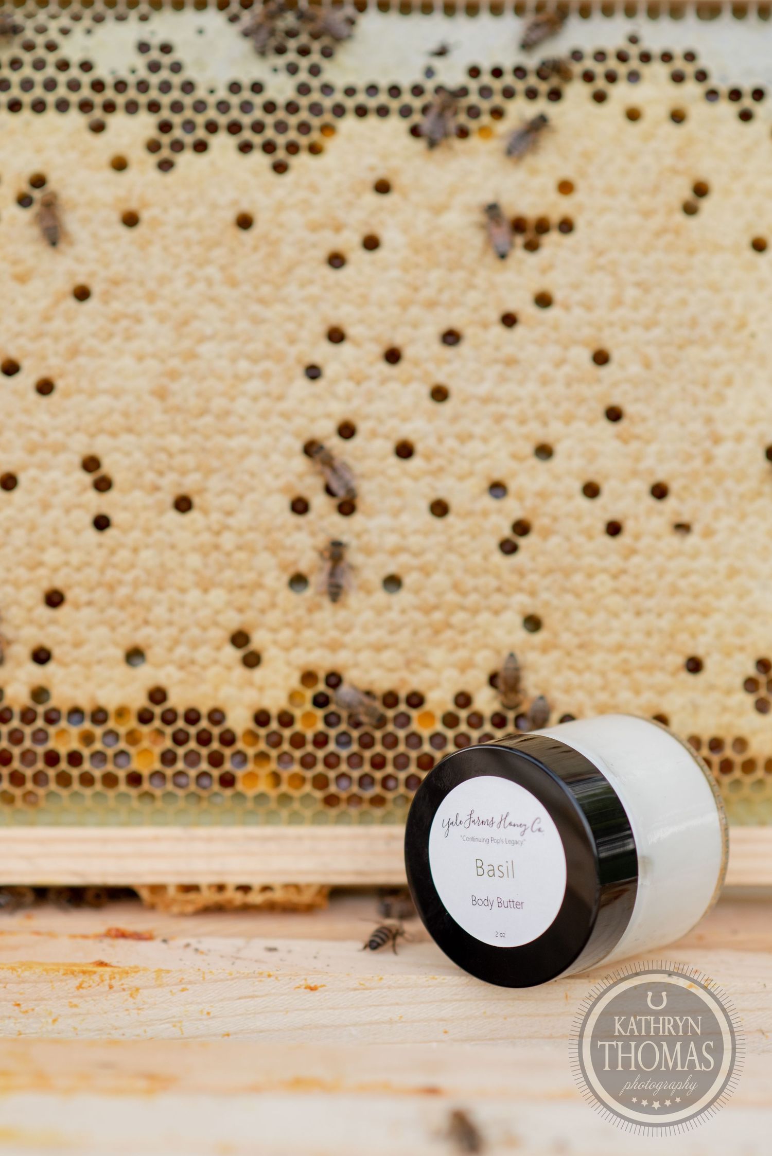 A jar of honey product with a labeled lid displayed against a honeycomb background.