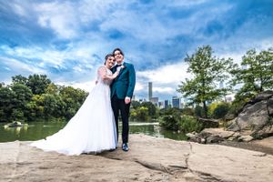 A romantic wedding photo captured in Central Park with the New York City skyline in the background.