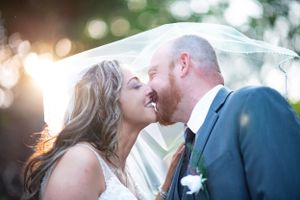 Romantic sunset wedding portrait with soft bokeh lighting effects.