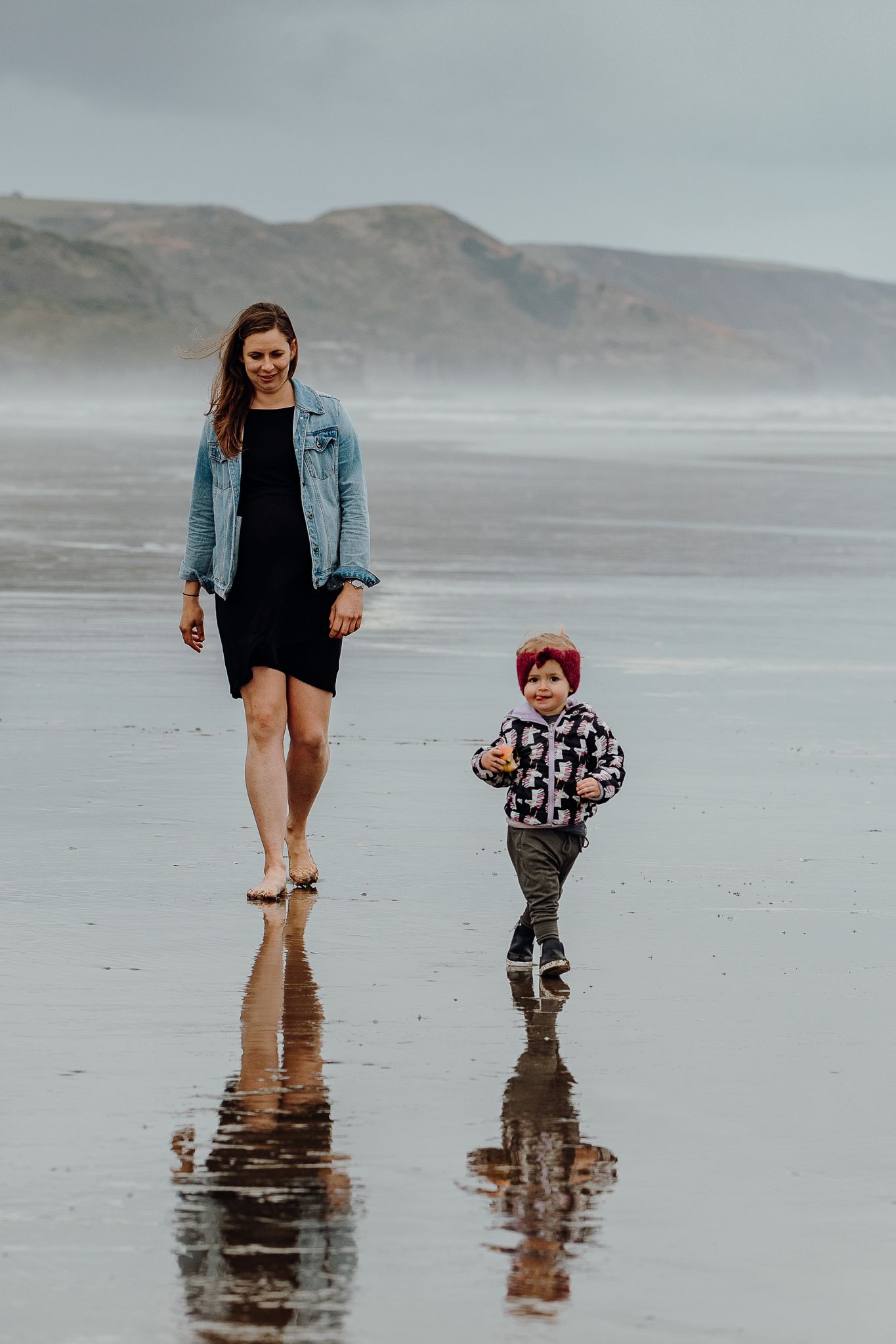 Mum looks so peaceful and content as she follows after her little girl - Muriwai Beach.