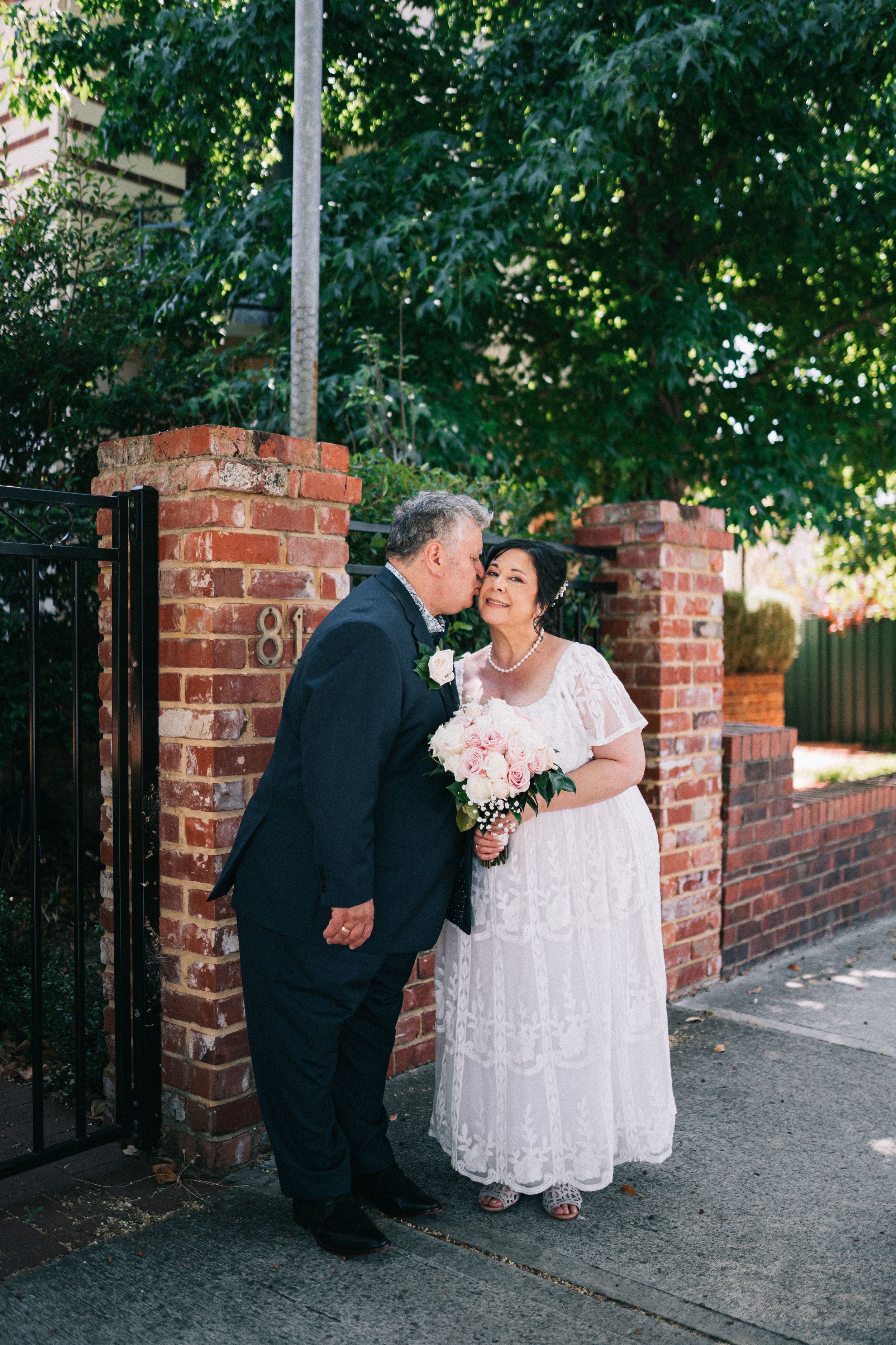 bride and groom wedding kiss on cheek