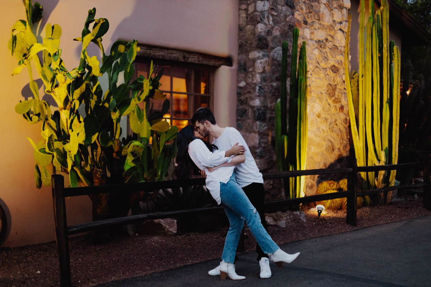 Evening photoshoot with couple near illuminated desert architecture.