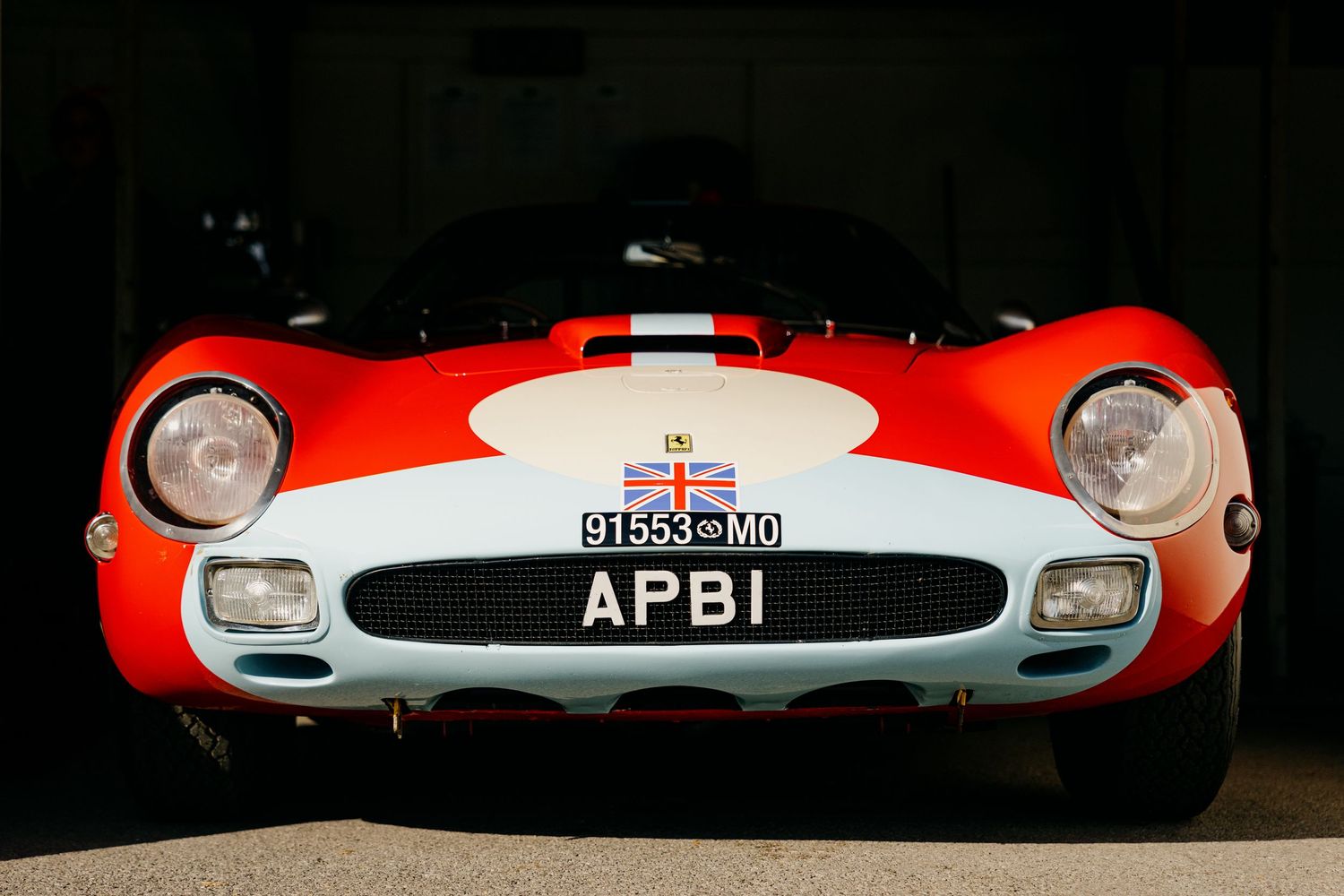Close-up fragments of classic racing cars showing red and white paint schemes and vintage details.
