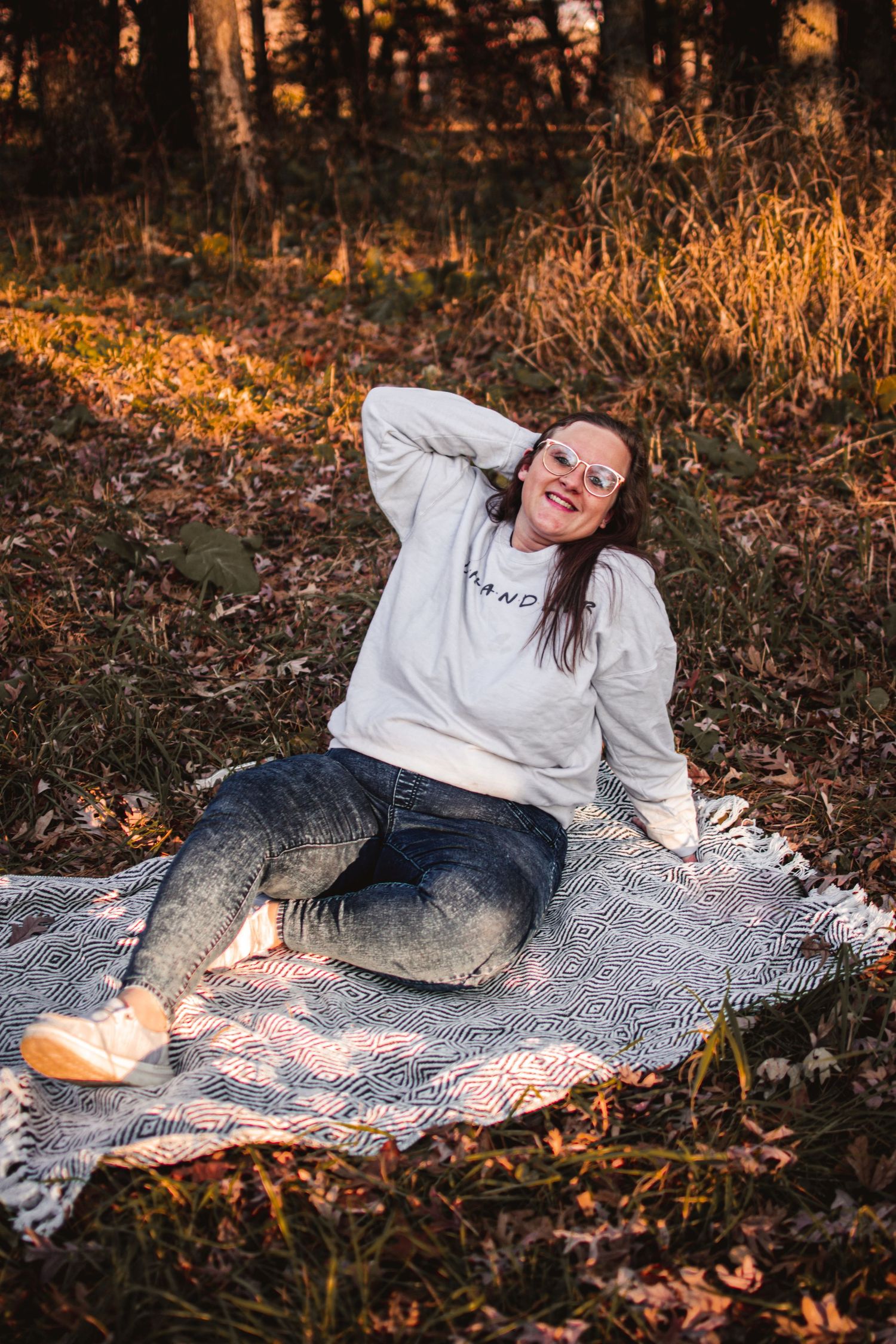 Someone relaxing on a blanket in autumn woods during golden hour.