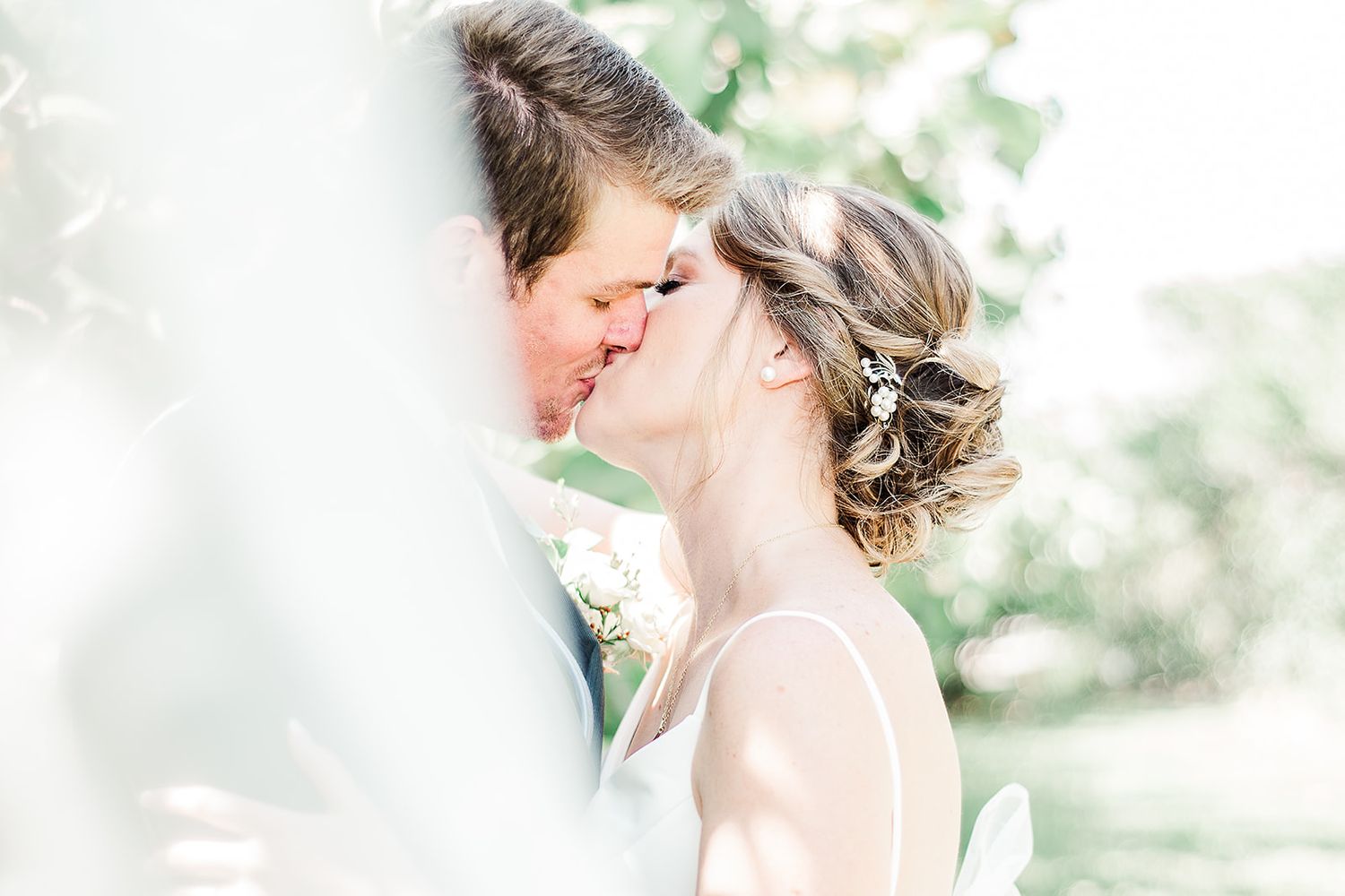 Romantic moment between couple in soft sunlit garden setting.
