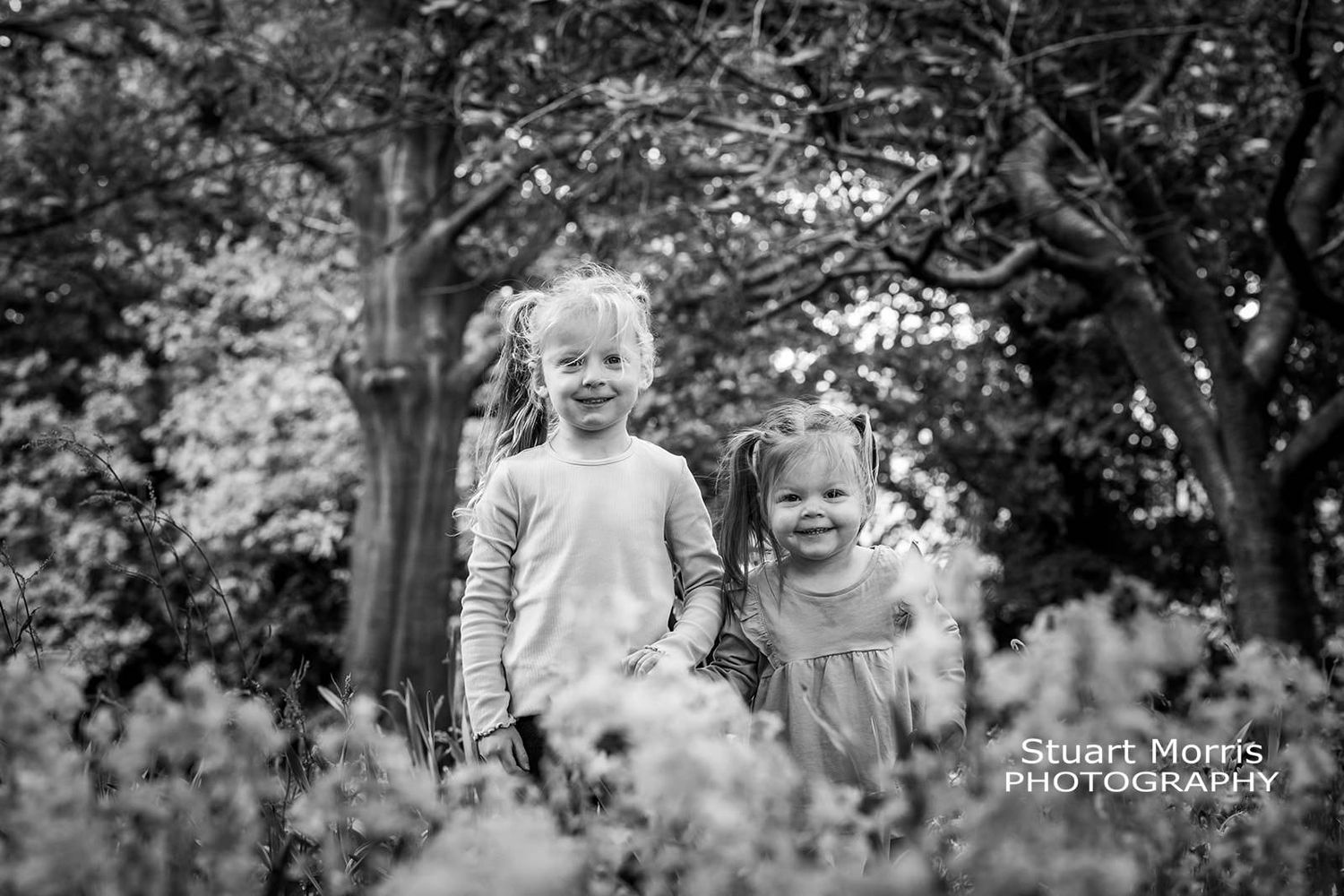 2 young girls playing in the woods during their mini portrait session. Walton hall gardens.