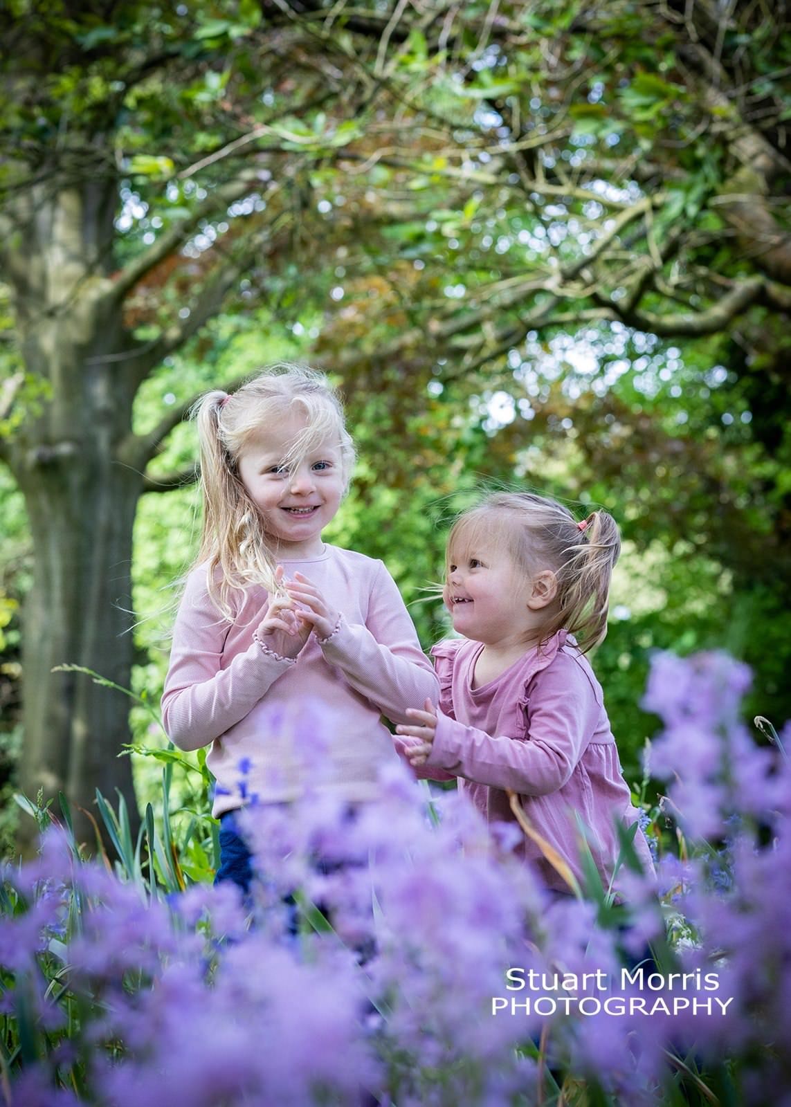 2 young girls playing in the bluebell woodlands during a mini portrait session. Stuart Morris Photography.