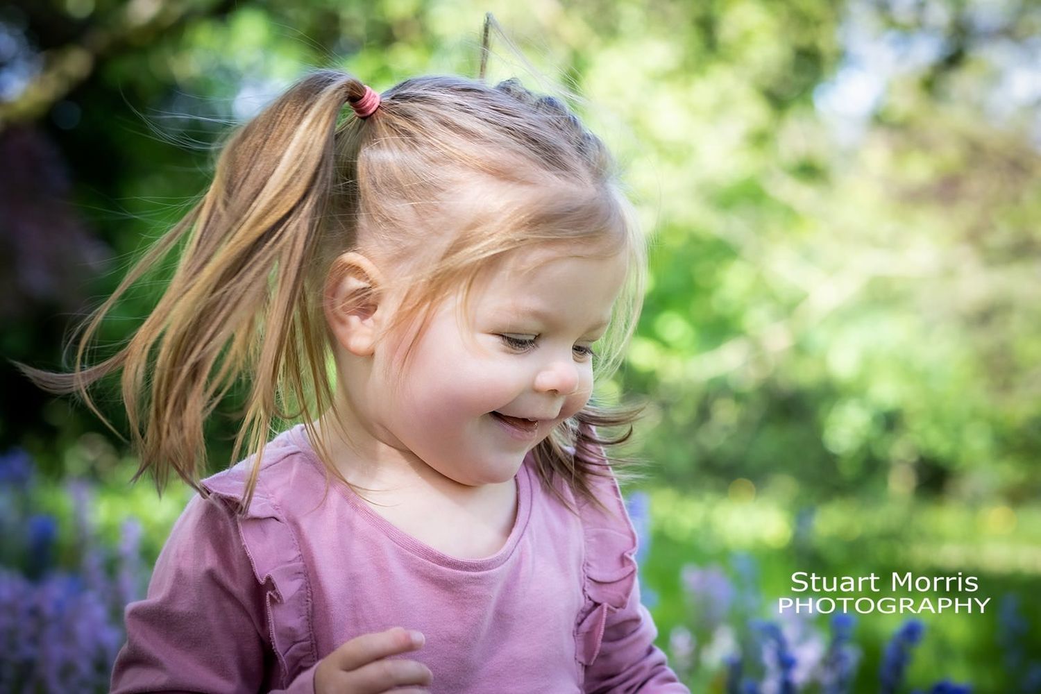 little girl smiling in the woodlands at Walton hall warrington. Cheshire portrait photographer.