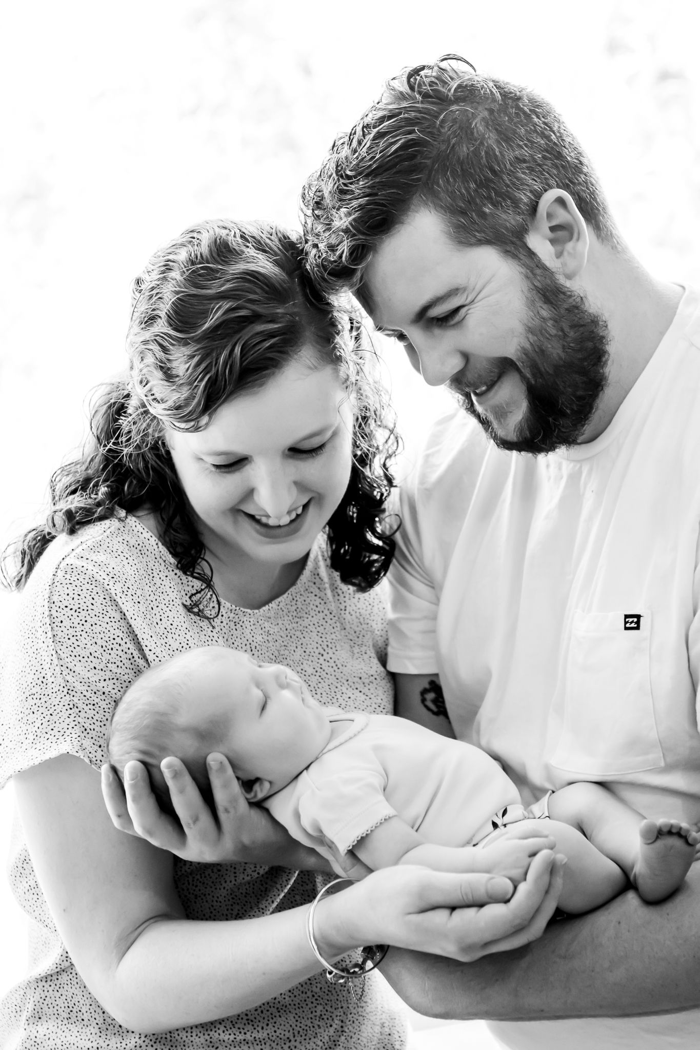 Mum and Dad looking down at their newborn baby
