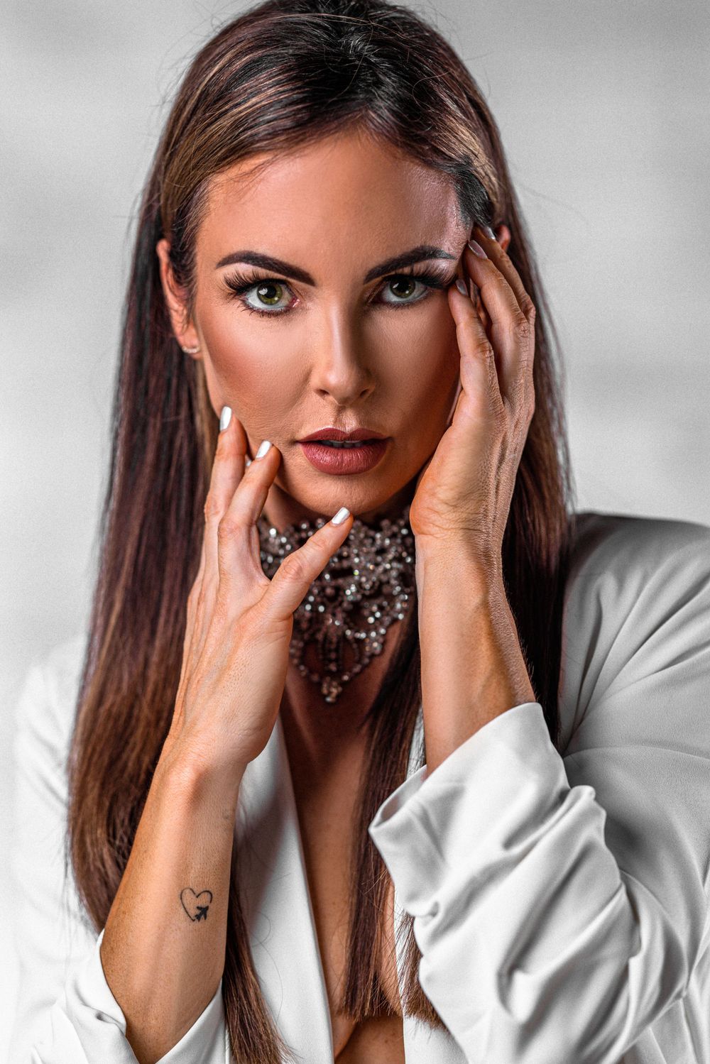 Close up beauty portrait featuring crystal choker necklace and white blazer.