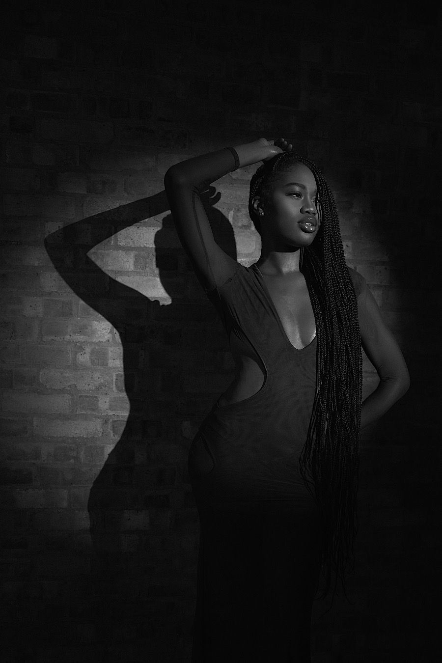 Artistic black and white fashion photo with dramatic lighting and dynamic pose.